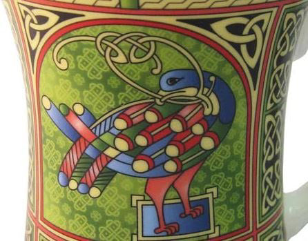 A detail of the peacock design. It looks back over its shoulder, showing off its multicolor feathers. The background is light green with shamrock shaped Celtic knots.