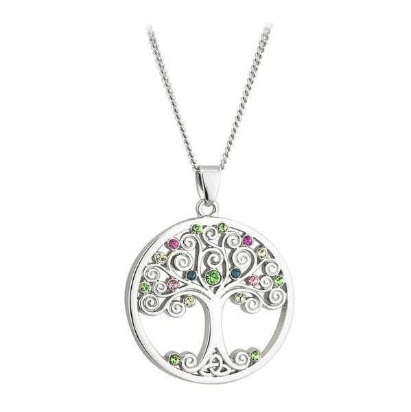 A round, silver tone necklace pendant of a tree with swirly branches decorated with multicolor glass crystals, and a trinity knot for roots.