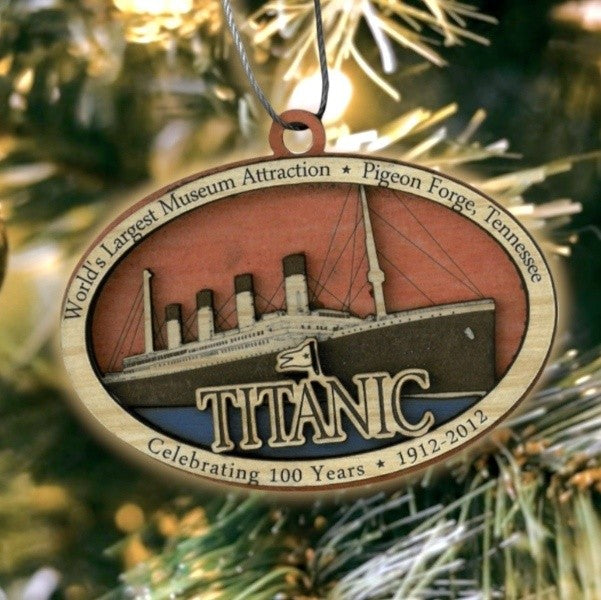 A wide oval ornament made of contrasting colors of wood. The Titanic is laser cut in detail with a TITANIC logo front and center.