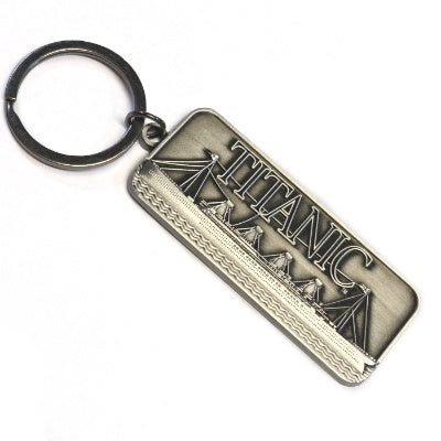 A rectangular metal key ring showing the Titanic ship embossed with its name.