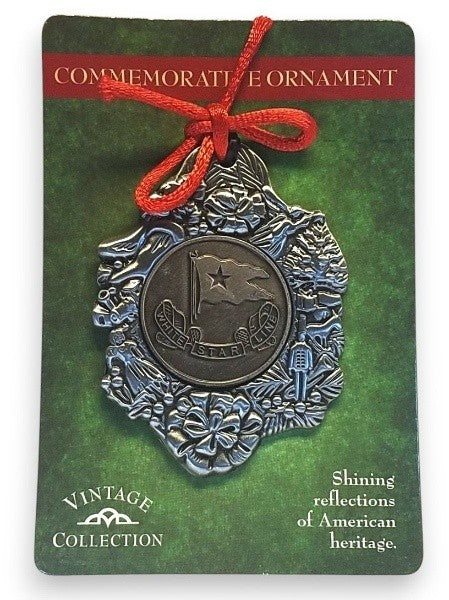 A pewter emblem of the White Star Line flag is decorated with a toy themed border made of antiqued silver tones and topped off with a red string bow.