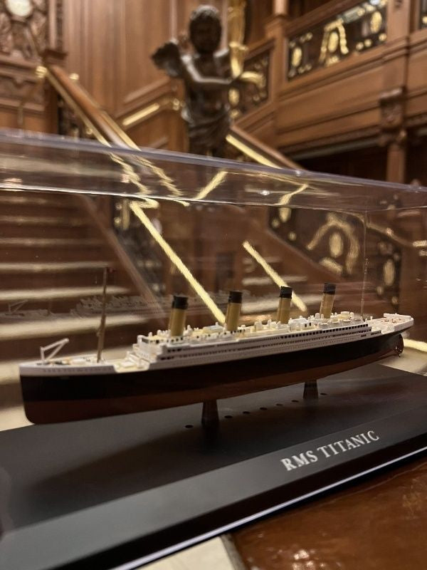 The diecast model of Titanic is displayed sitting in the full-sized replica of the Grand Staircase.