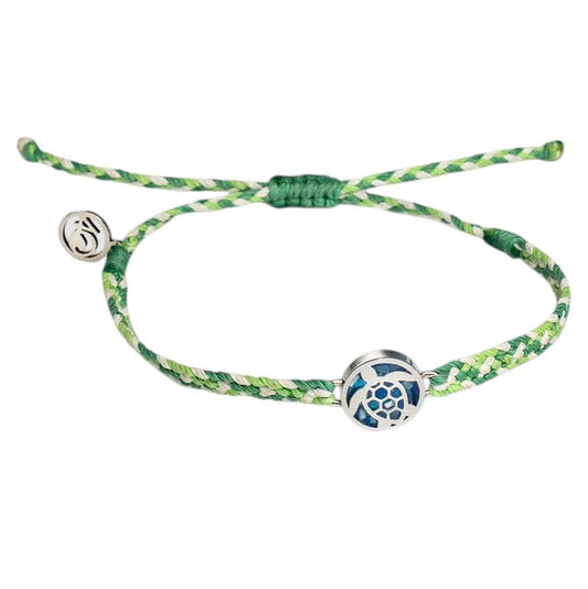 A macrame braided bracelet with a speckled green, lime, and white pattern. It has a silvery steel charm of a sea turtle filled with blue recovered microplastics.