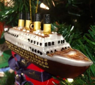A blown glass Titanic ornament with painted and glittery gold details.