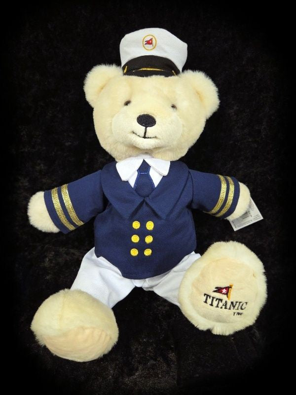 Polar bear plush in navy, white, and gold captain costume and an embroidered logo on its foot.