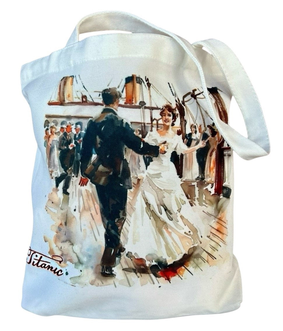 A white canvas tote bag with a watercolor image of a man and woman dancing on Titanic's deck as a crowd watches. The woman is in a white dress and the man is in a black suit.