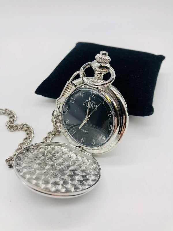 Silver-tone pocket watch in open position displaying a black watch face with white numbers one through twelve and silvery hands.