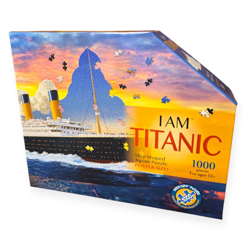 Front of box for I Am Titanic puzzle. Puzzle pieces show Titanic ship with blue sky. Box has sunset colors of blue, orange, and pink.