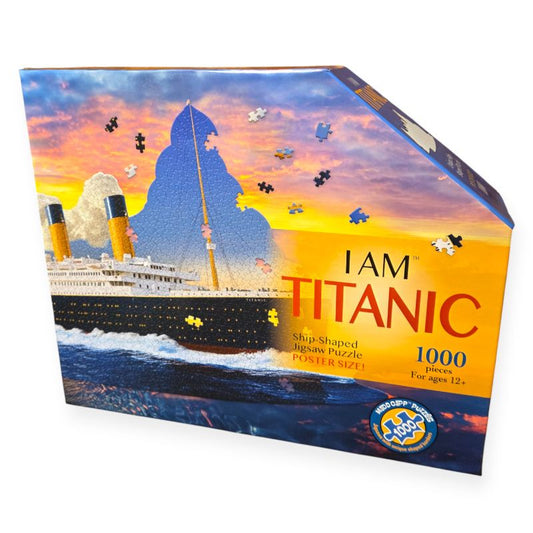 Front of box for I Am Titanic puzzle. Puzzle pieces show Titanic ship with blue sky. Box has sunset colors of blue, orange, and pink.