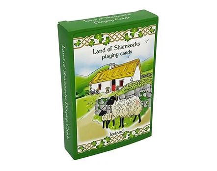 A green box of standard sized playing cards decorated with an illustration of a traditional Irish home and a mother and baby sheep beside a cobblestone wall.