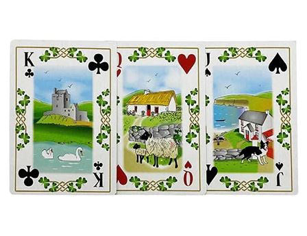 Each playing card has Celtic knot and shamrock details along the border. The King shows swans in a lake by an old castle, the Queen shows sheep by a cabin, and the Jack shows a border collie playing in a field by the shoreline.