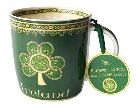 The same image of a green shamrock mug with yellow Celtic knots, this time with the product's matching tag attached.