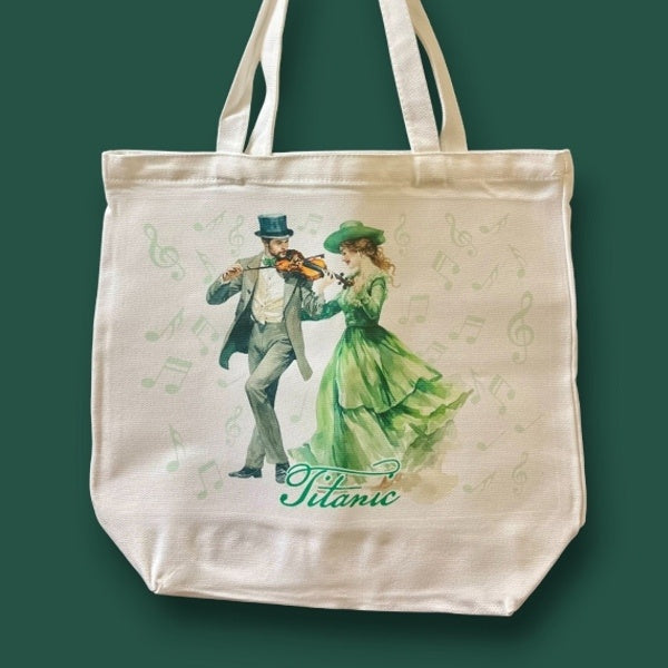 A large off-white canvas tote bag printed with a formally dressed Irish couple enjoying a merry fiddle tune.