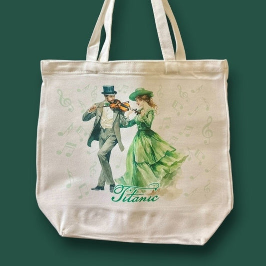 A large off-white canvas tote bag printed with a formally dressed Irish couple enjoying a merry fiddle tune.