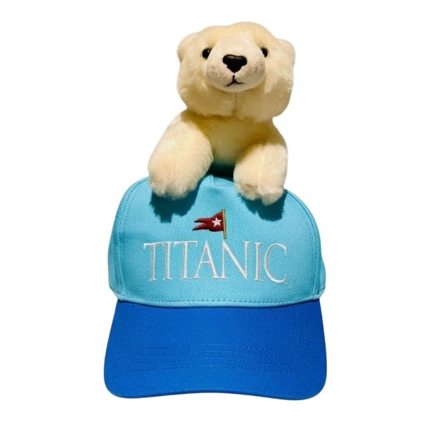 A view straight on of the youth Titanic baseball cap with embroidered logo and a plush polar bear on top.