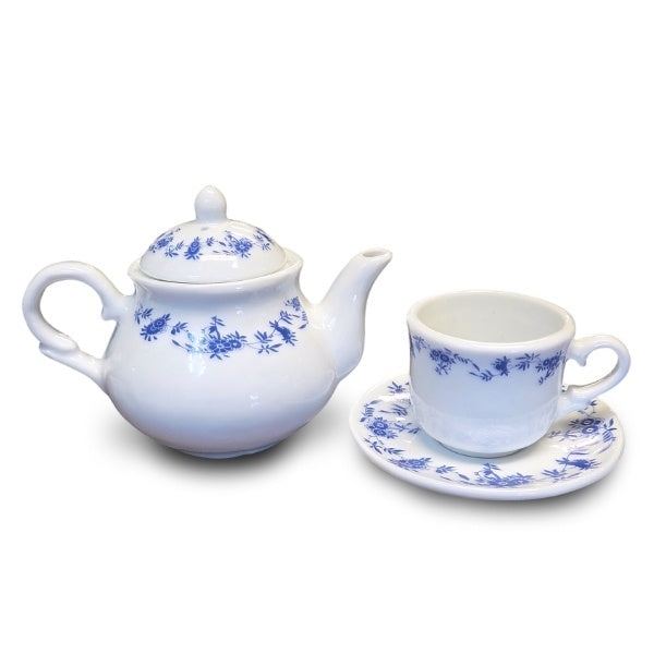 A mini teacup and teapot set with dark blue floral trim on white ceramic. The teacup is slightly smaller than a shot glass.