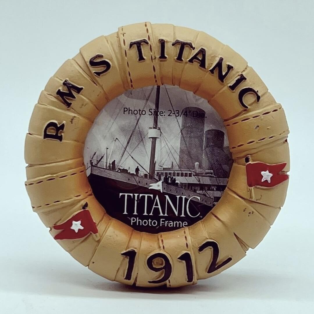 A miniature photo frame in a circle life-ring shape. The life ring is a vintage light brown and decorated with two red White Star Line flags. It says RMS Titanic 1912.