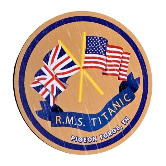 A light brown magnet with faux wood grain. The national flags of the United Kingdom and United States are waving with their poles crossed, a navy banner below says RMS TITANIC. The design is framed with a navy ring and the words Pigeon Forge, TN.