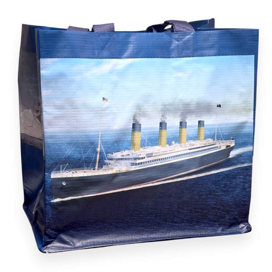 A large blue shopping tote bag with an illustration of Titanic sailing on a bright day under clear skies.