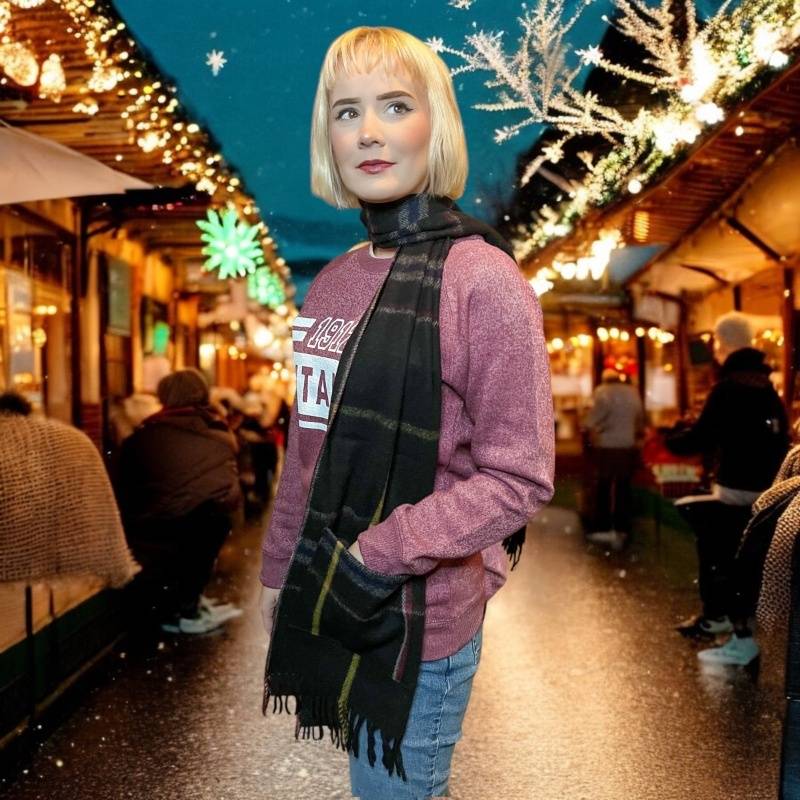 A blonde young woman wears the Spirit of Titanic pocket scarf wrapped around her neck, with one hand placed in a pocket of the scarf near her hip.