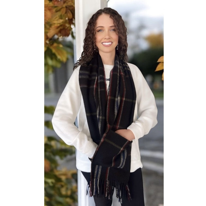 A brunette woman has her hands in the pockets of the Spirit of Titanic scarf to keep warm.