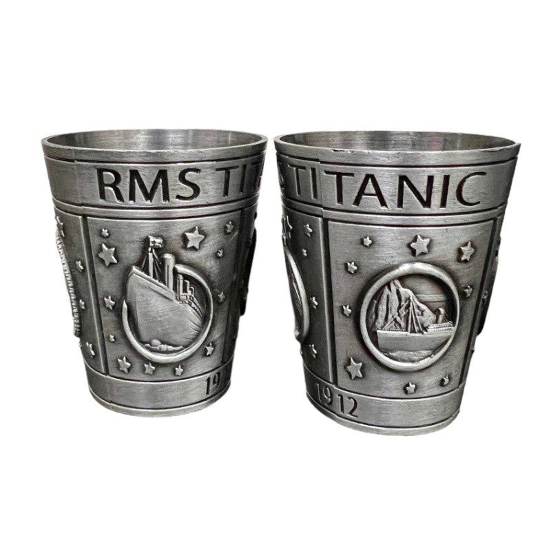 Pewter Titanic shot glass from two sides on a plain white background.