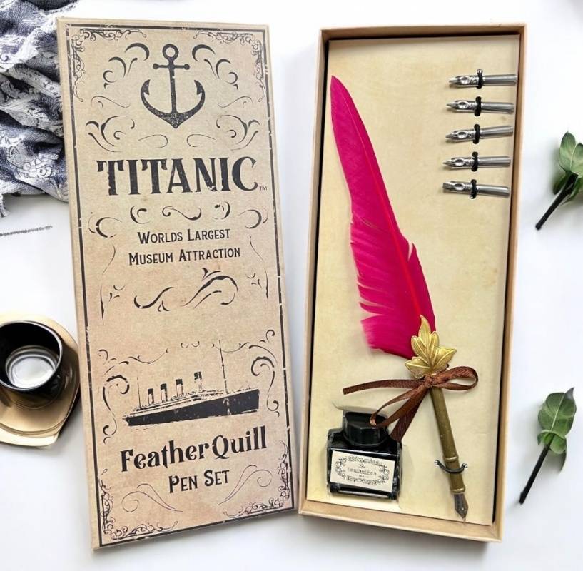 Bright red feather quill pen in a beige box with Titanic design on the cover.