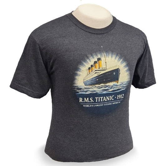 A graphite grey t-shirt on a mannequin. It has a round image with a sunburst outline that shows the Titanic in full color above the words RMS Titanic 1912.