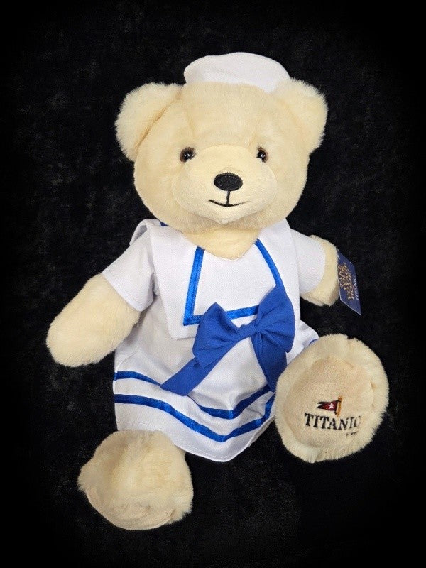 Polar bear plush wearing white sailor dress and blue details.