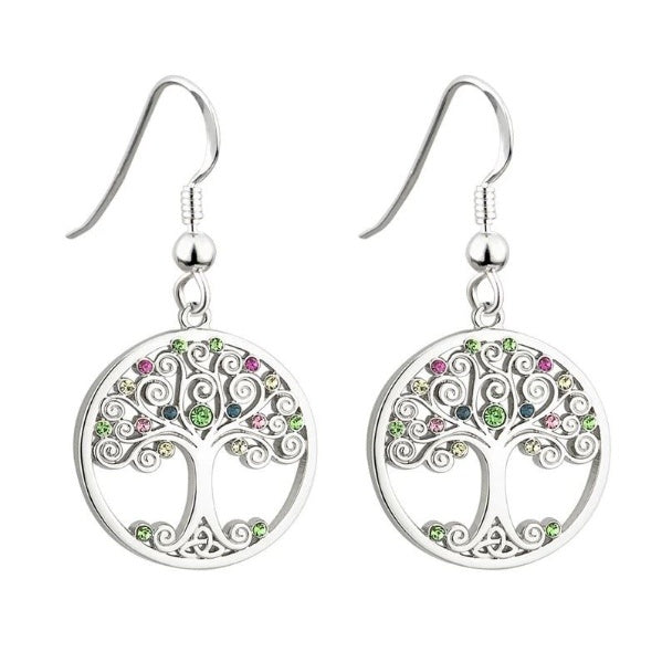 A pair of round, silver tone earrings of a tree with swirly branches decorated with multicolor glass crystals, and a trinity knot for roots.