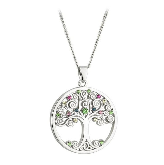 A round, silver tone necklace pendant of a tree with swirly branches decorated with multicolor glass crystals, and a trinity knot for roots.