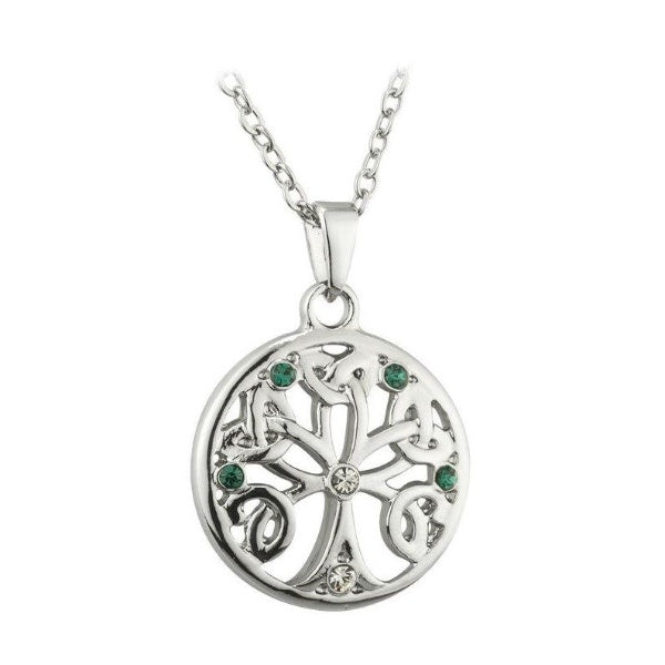 A silver-tone round pendant depicting a tree with branches woven into Trinity Knots. It is accented with small clear and green crystals.