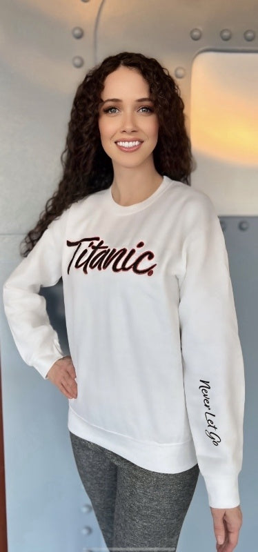 Woman with curly dark hair poses in the Titanic Sparkling sweatshirt.