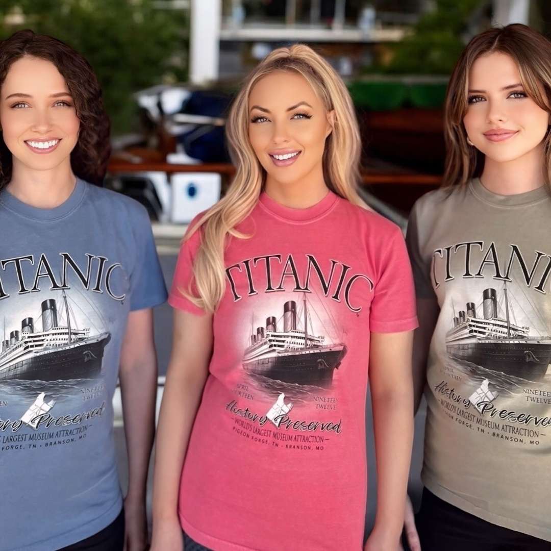 Three young women, each wearing a Titanic History Preserved t-shirt in different colors.