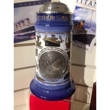 Collectable Titanic stein in blue and white with gold icons, domed metal top, and large embossed Titanic sinking emblem.