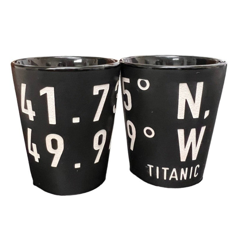 Matte black shot glasses engraved with bold white numbers and the name Titanic.