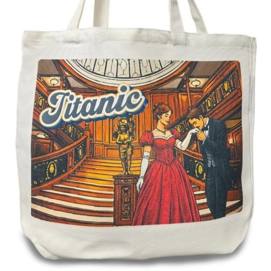 A white canvas tote bag printed with an image of a gentleman kissing a woman's glove on the grand staircase under the word "Titanic".