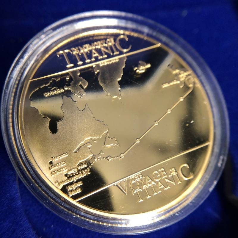 Back of gold Titanic coin featuring map of the ship's route.