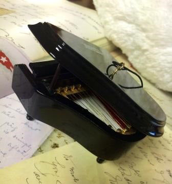 From the side you can see the strings inside the piano's body, looking almost like a harp laying flat.