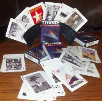 A deck of playing cards strewn across a table and fanned out in a card-holder. There are a mix of black and white photos and colorful poster images, a different one printed on each card.