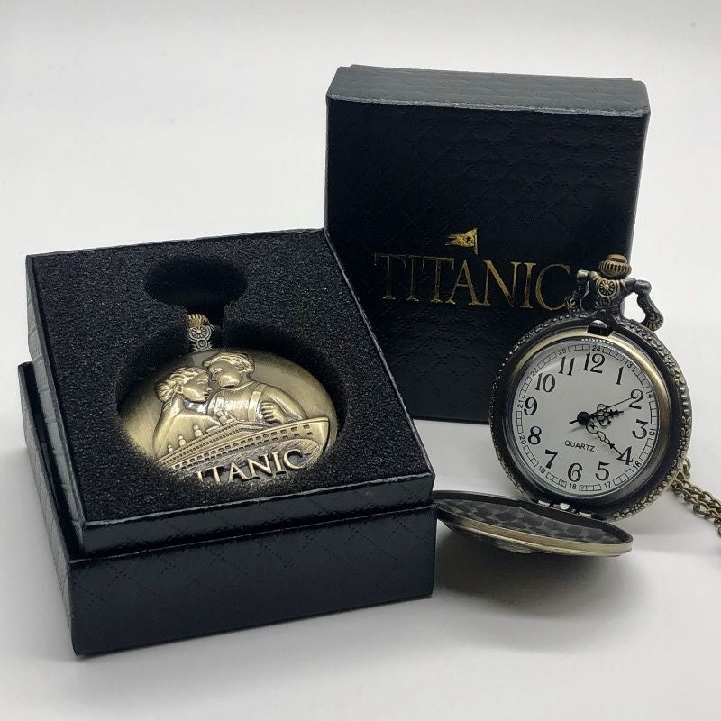 Necklace version of an antique brassy pocket watch displayed in its box and open to show a white watch face with swirly black hands and large numbers one through twelve.
