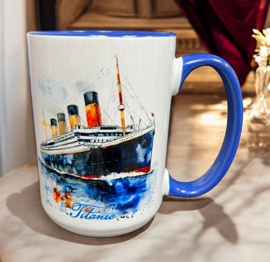 A white mug with sky blue handle and interior, with a watercolor image of the Titanic on the front.