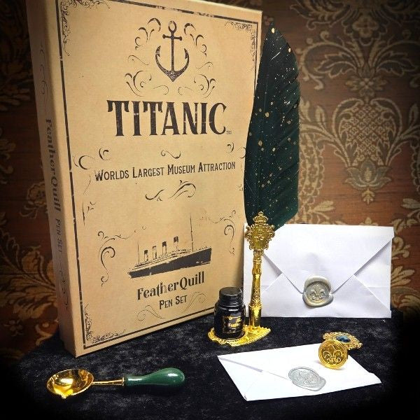 A custom Titanic themed gift box with pieces of a feather quill and wax seal stationery set displayed on a black velvet tablecloth.